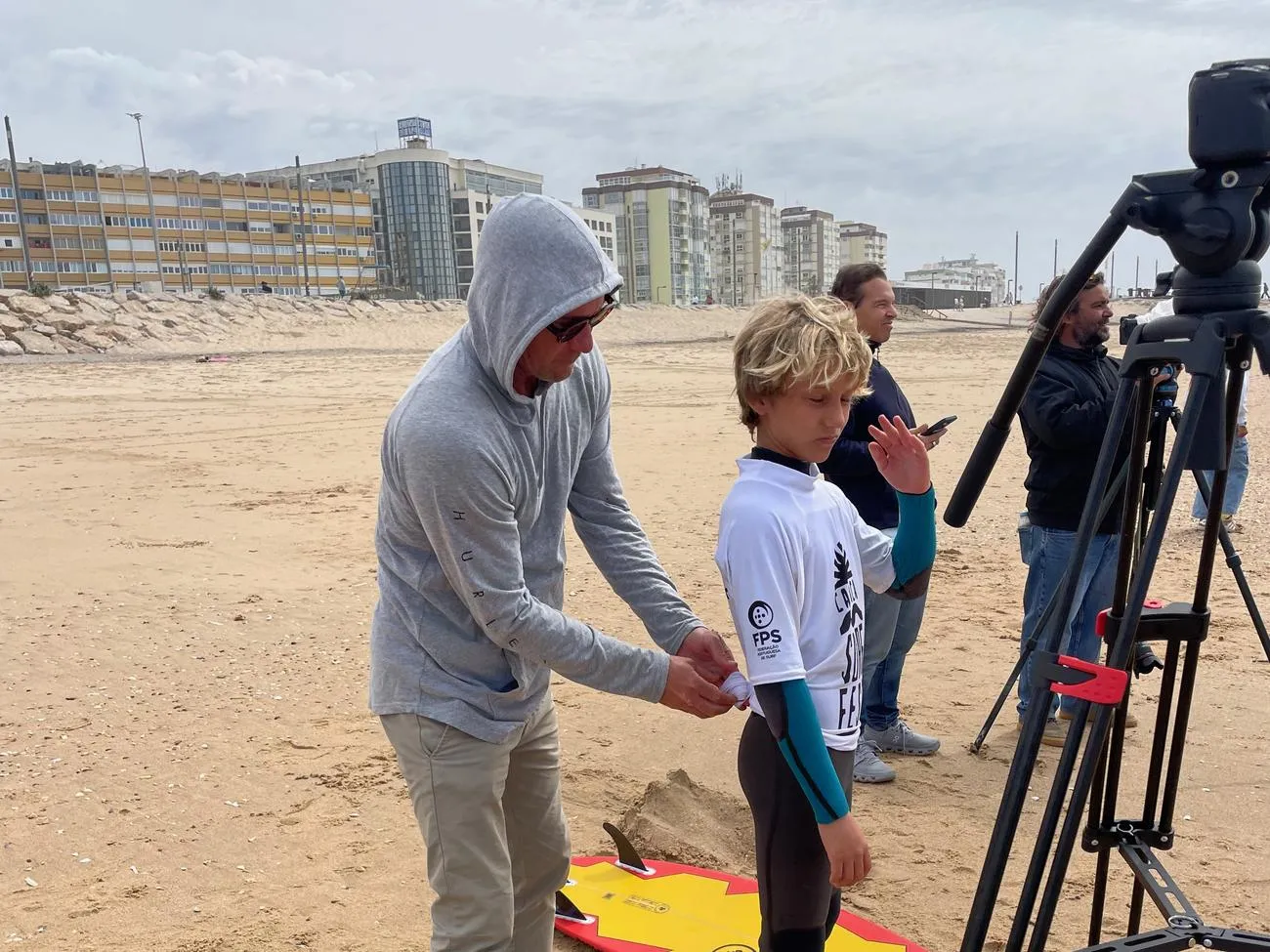 Justin adjusting a young competitor's jersey next to the video tripod